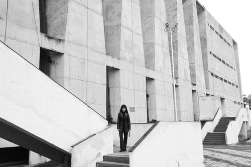 Free Black and white image of modern architecture with a person in a leather jacket. Stock Photo