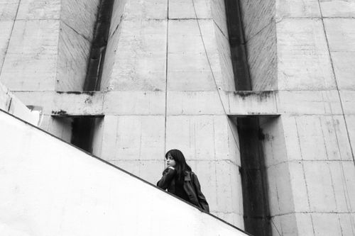 Free Woman in black and white urban setting, modern architecture. Stock Photo