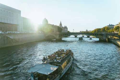 Free Enjoy a picturesque boat cruise on the Seine River, capturing historic Parisian architecture under a warm daylight. Stock Photo