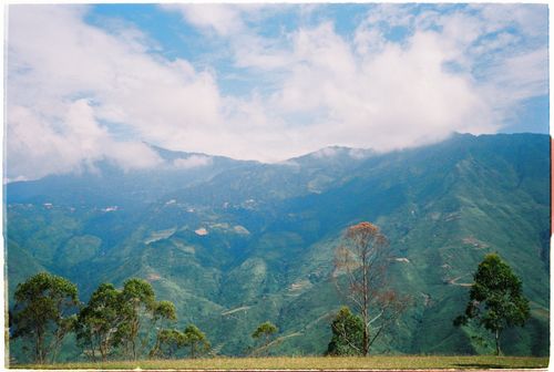 Free A picturesque view of a lush green mountain range beneath a cloudy sky. Stock Photo