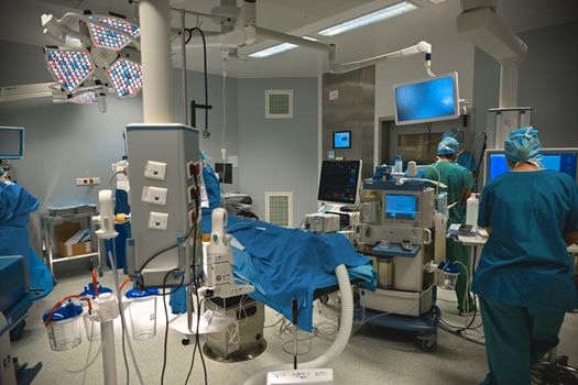 A modern operating room with medical staff performing surgery, equipped with high-tech instruments.