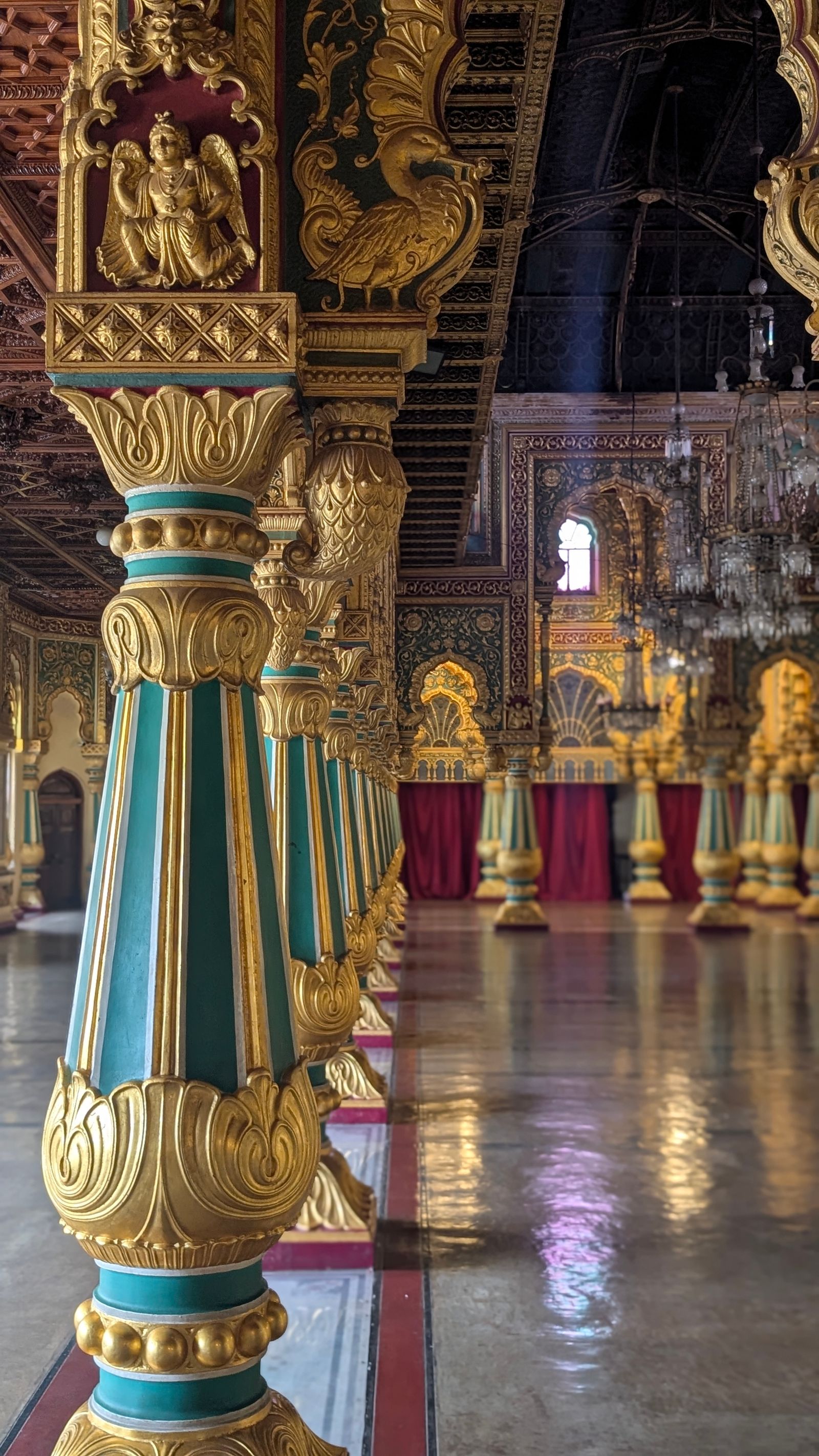 Gold and teal pillars inside Mysore Palace, a popular weekend trip from Bangalore