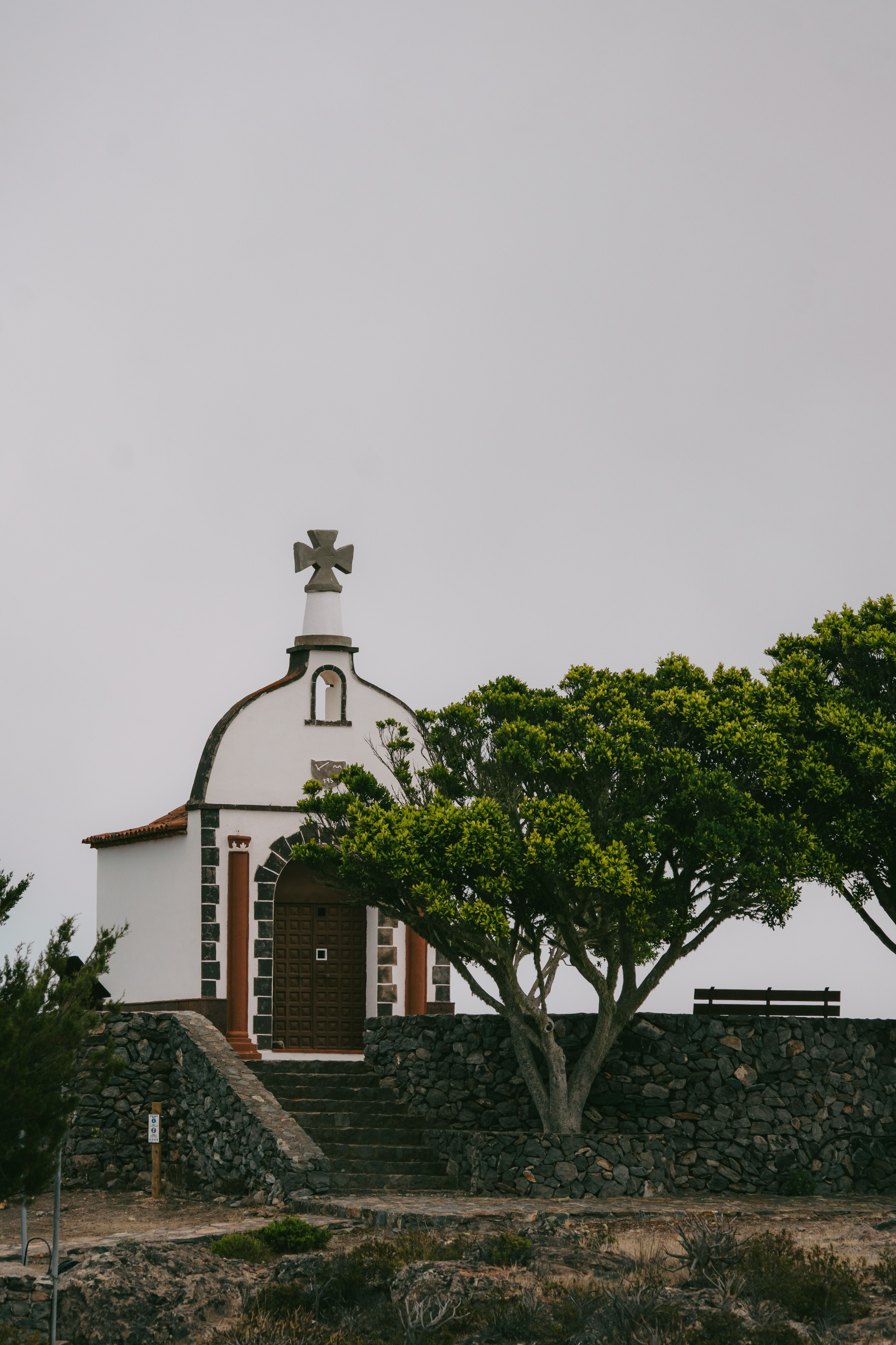 Fotomural Encantadora capilla blanca rodeada de árboles en Alajeró, Islas Canarias.