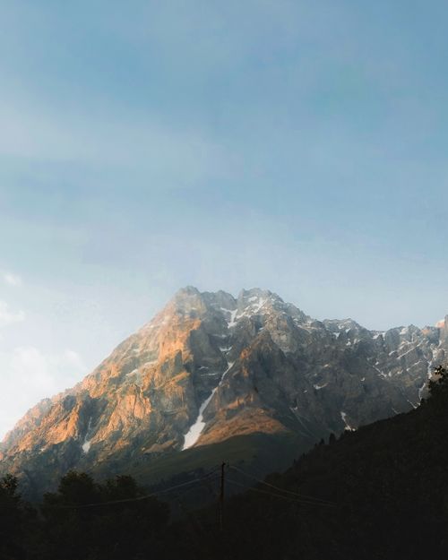 Free Breathtaking view of a majestic mountain range during sunset with snow-capped peaks. Stock Photo