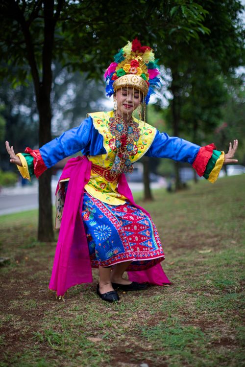 Free A dancer in colorful traditional attire performing outdoors in Jakarta, Indonesia. Stock Photo