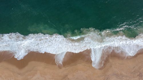 Free Aerial view of the waves crashing on the shores of Algarrobo Beach in Chile. Stock Photo