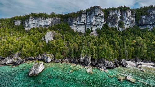 Free Stunning limestone cliffs with lush greenery by crystal-clear waters in Bruce Peninsula, Ontario. Stock Photo