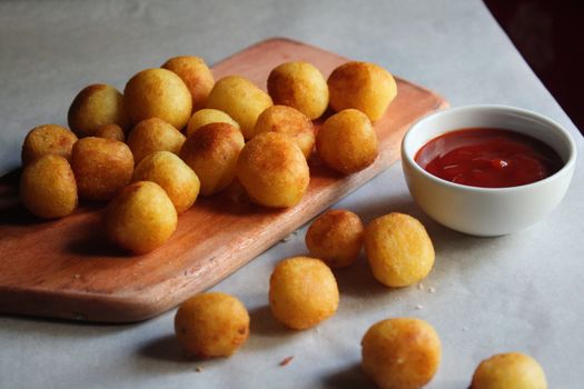 Crispy potato balls served with a side of tangy tomato ketchup.