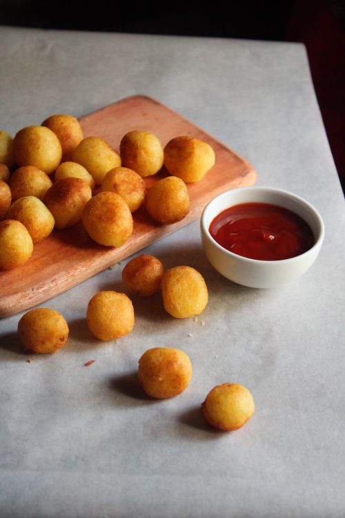 Free Golden fried potato balls served with tomato ketchup on a wooden board. Stock Photo