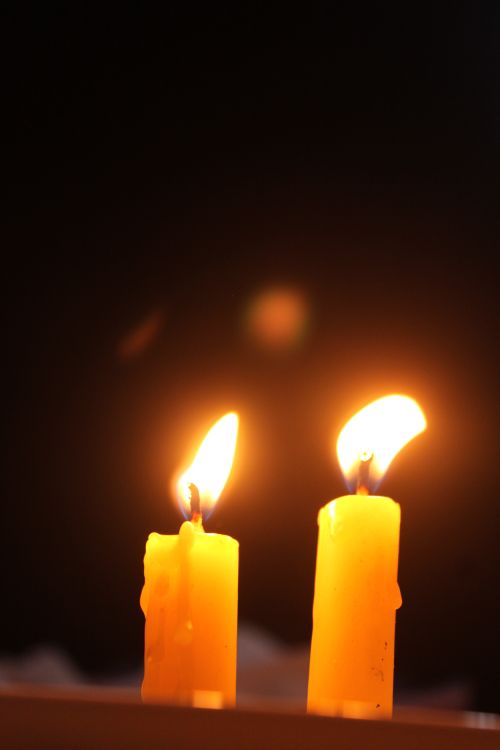 Free Close-up of two lit candles against a dark backdrop, creating a cozy and intimate atmosphere. Stock Photo