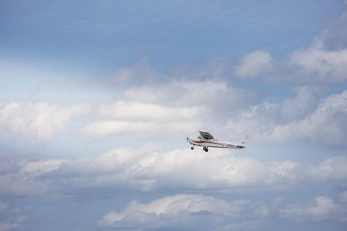 Free A small aircraft navigating through a bright sky, surrounded by fluffy clouds. Stock Photo