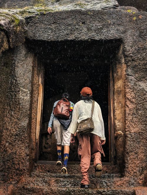 Free Two people explore an ancient stone doorway in Mumbai, India, showcasing adventure and history. Stock Photo