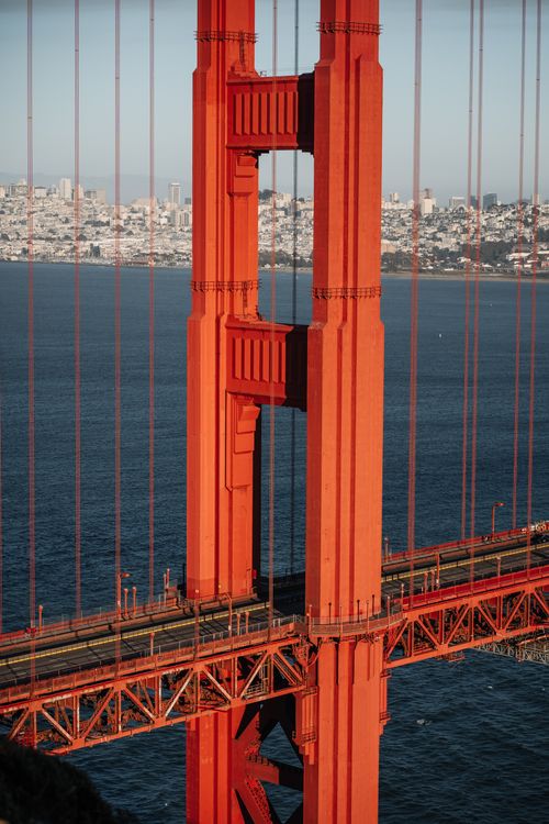 Free A close-up view of the iconic Golden Gate Bridge tower with cityscape in the background, San Francisco. Stock Photo