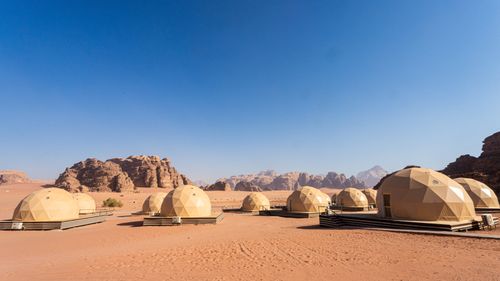 Free Modern geodesic domes in the scenic Wadi Rum desert, Jordan, under a clear blue sky. Stock Photo