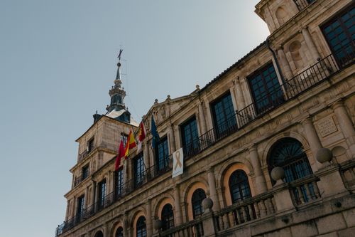 Free Low-angle view of a historic government building with flags in the sunlight. Stock Photo