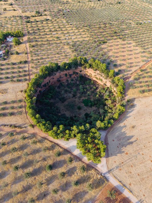 Free Stunning aerial view of a lush crater surrounded by farmland in Greece. Stock Photo