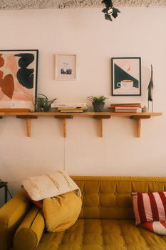 Warm and inviting living room with artwork, books, and cozy seating.