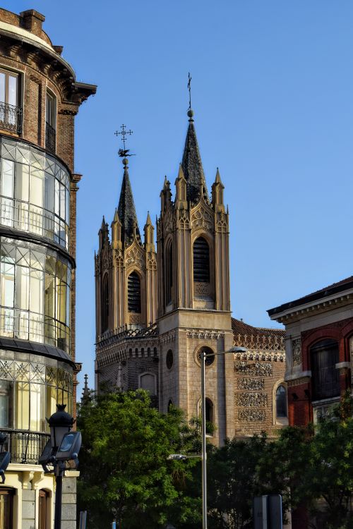Free Stunning view of a Gothic cathedral amid urban architecture under a clear blue sky. Stock Photo