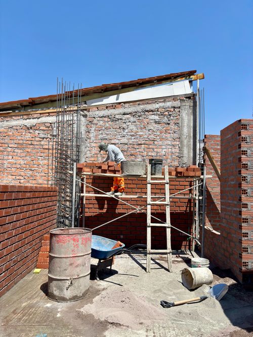Free A bricklayer skillfully builds a wall on a sunny day, showcasing construction craftsmanship. Stock Photo
