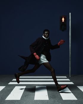 A stylish individual crossing a zebra pedestrian in Lagos, Nigeria.