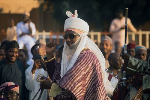 Free Dynamic scene of a cultural festival featuring a man in traditional Emir attire among a lively crowd. Stock Photo