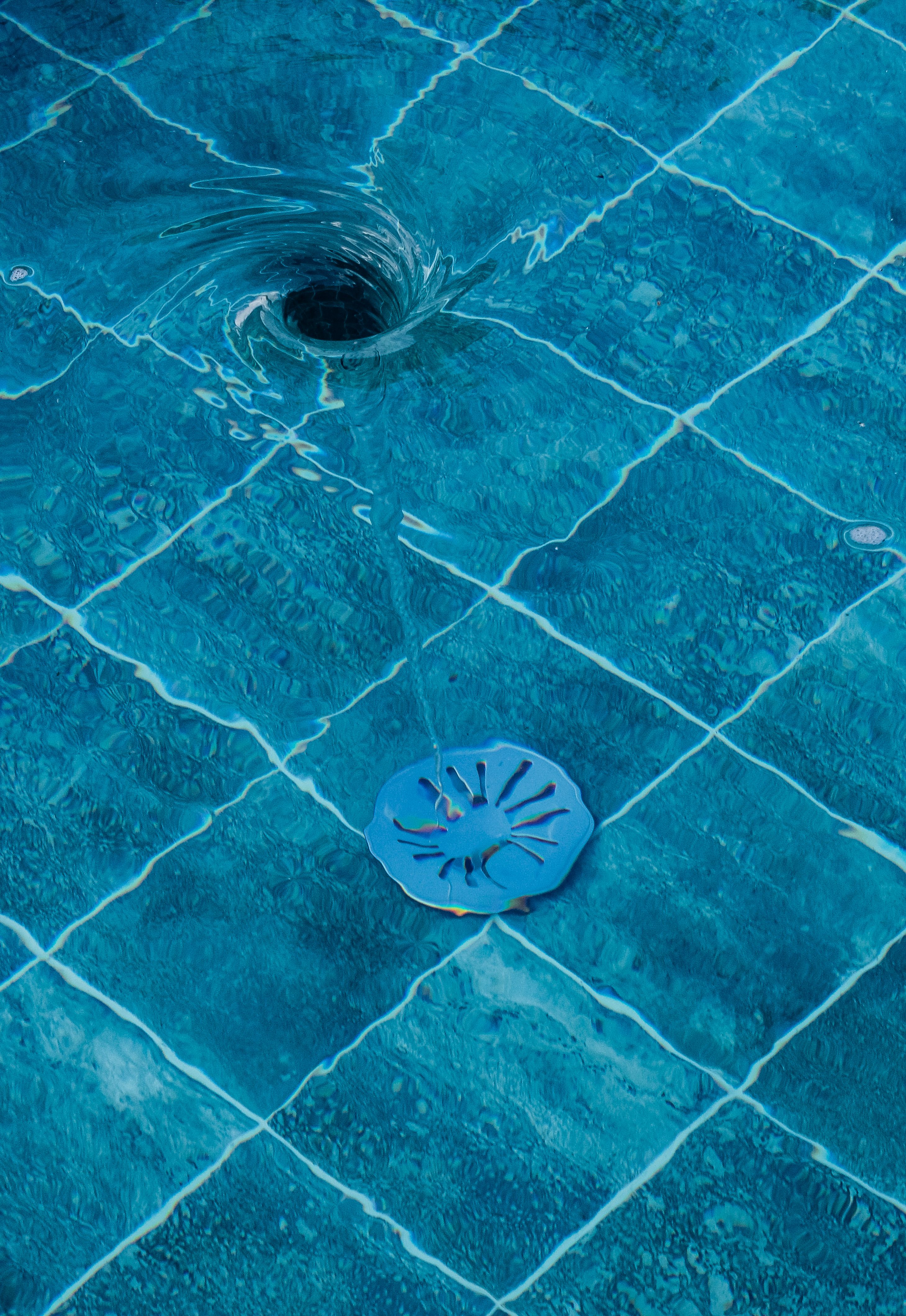 Redemoinho de água sobre azulejos azuis de piscina