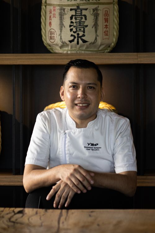 Free Portrait of a professional chef in uniform sitting indoors with traditional decor. Stock Photo