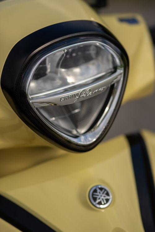 Free Detailed view of a yellow scooter headlamp showcasing modern design elements. Stock Photo