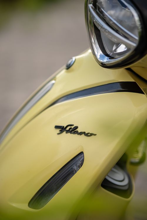 Free Detailed view of yellow scooter's headlight and branding with a sleek design. Stock Photo