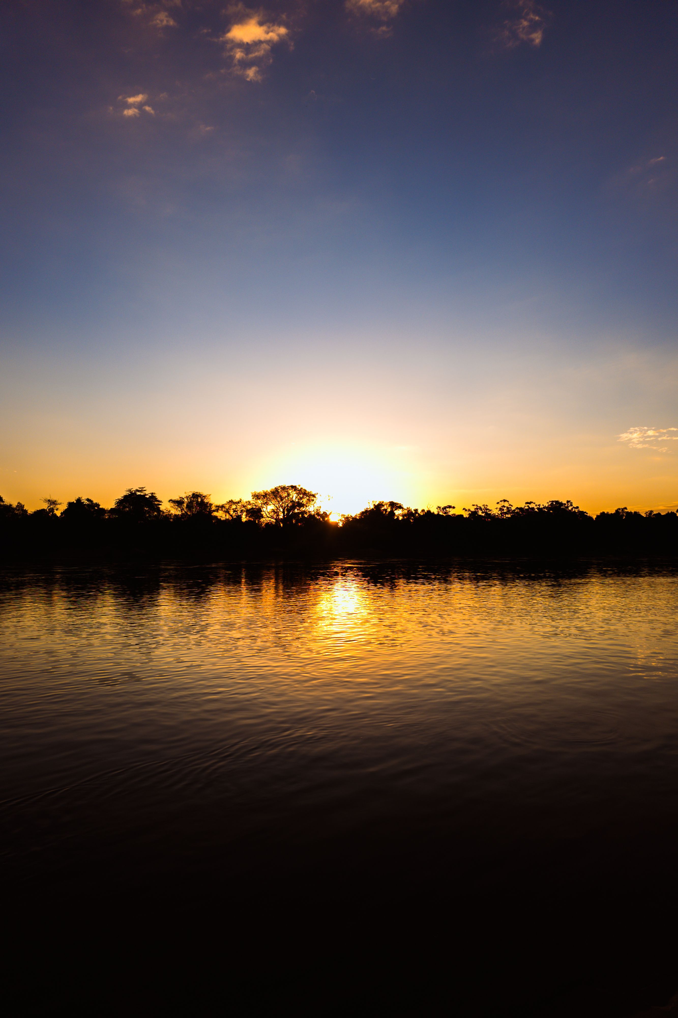 Stunning sunset over a tranquil river in Luiz Alves, Goiás, Brazil.