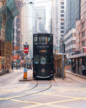 在香港充满活力的城市街道上，经典的黑色电车在白天行驶