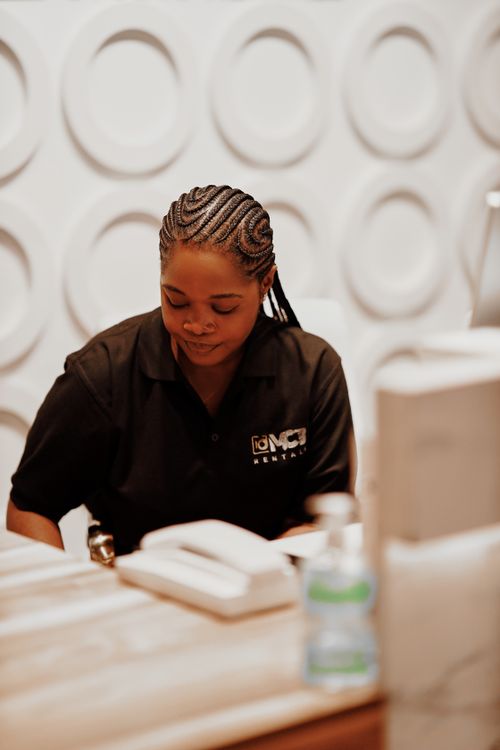 Free Focused woman working at desk in a modern office setting, shirt with company logo. Stock Photo