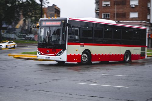 Free Public bus navigating a roundabout in Montevideo during a rainy day. Stock Photo