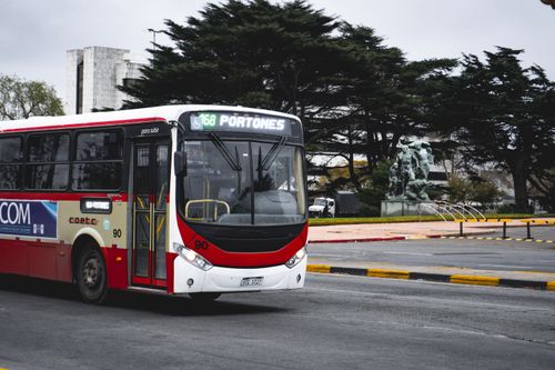 Free A public bus in Montevideo passes by a monument, showcasing urban life in Uruguay. Stock Photo