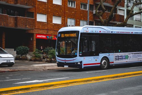Free City bus on a street in Montevideo, Uruguay near a residential block and toy store. Stock Photo