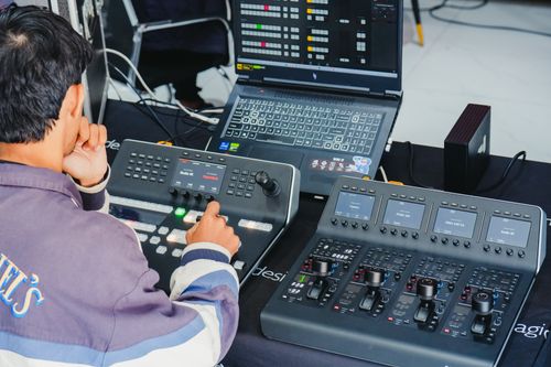 Free Audio engineer using a digital mixer with laptop in a control room setting. Stock Photo
