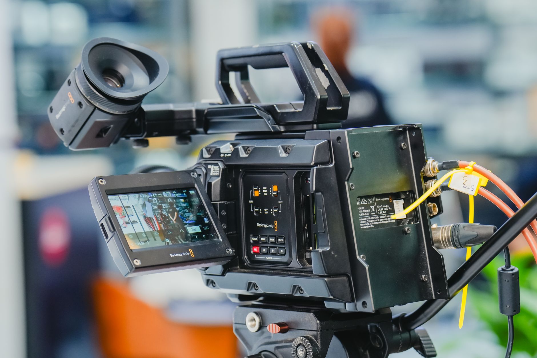 Close-up of a professional video camera setup in an indoor studio environment.