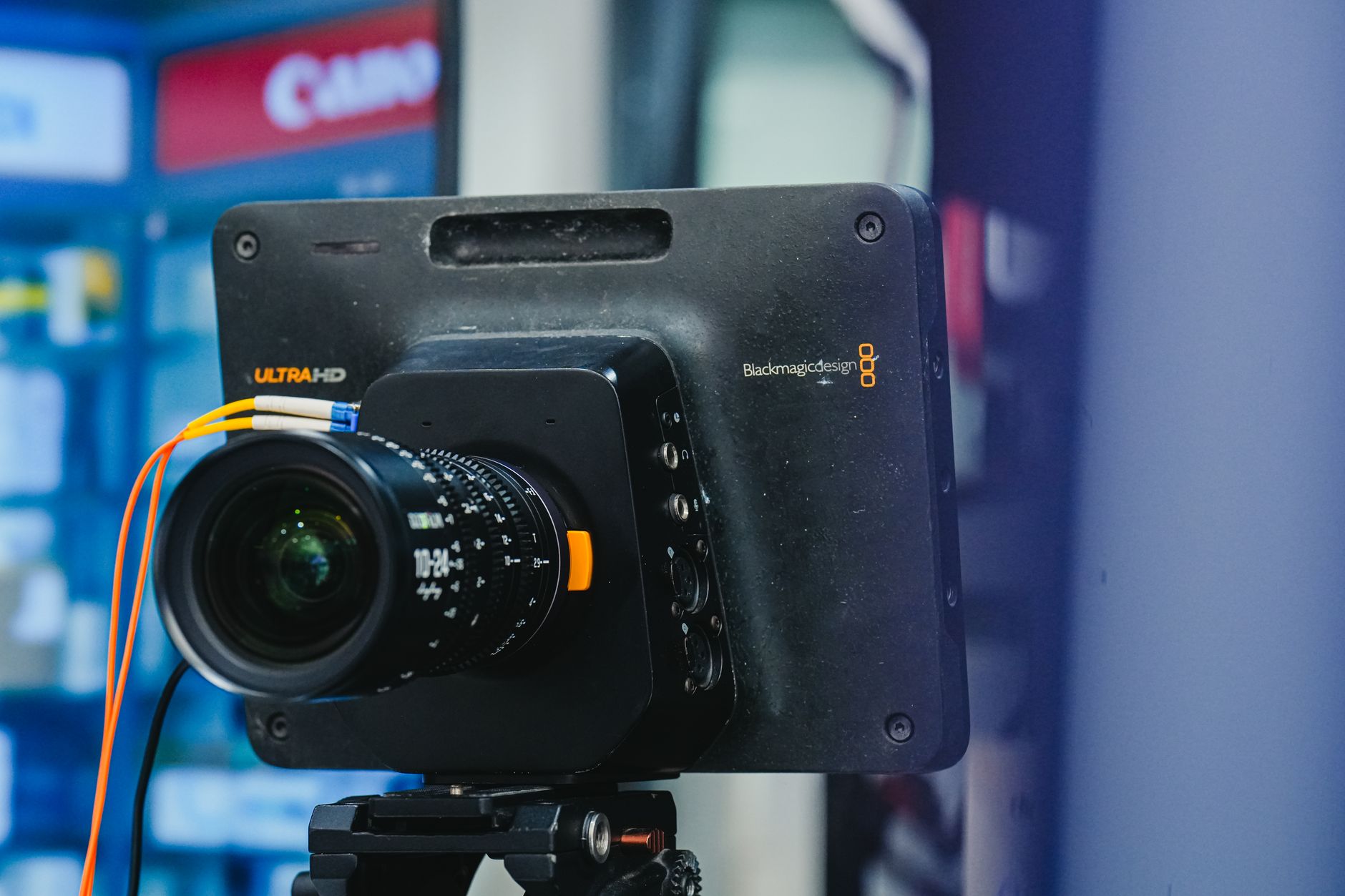 Close-up of a professional video camera setup with lens on a tripod, ideal for filming.