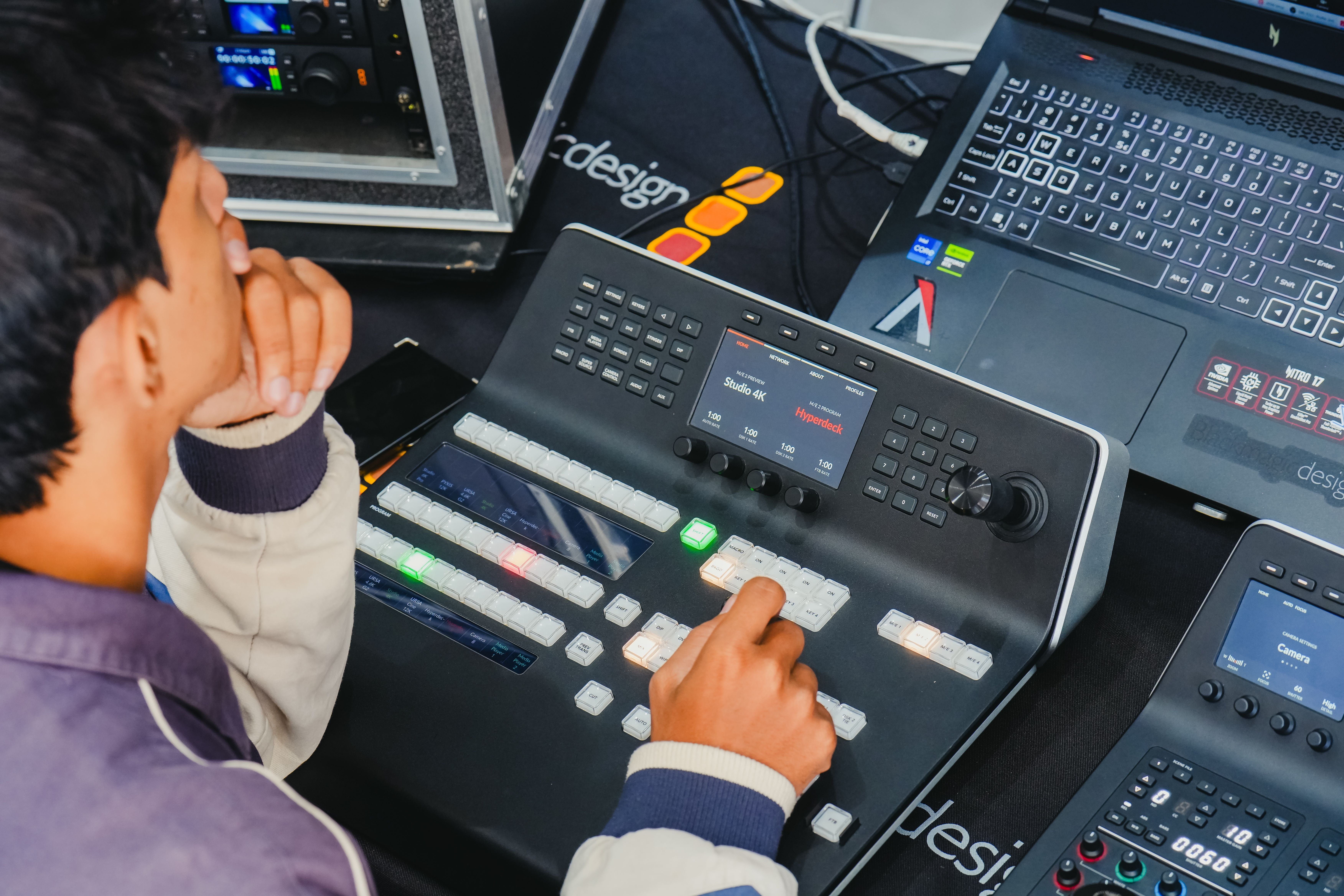 A man operating a video editing console in a high-tech studio setup.