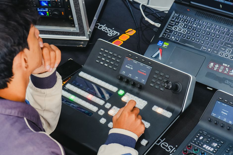 A man operating a video editing console in a high-tech studio setup.