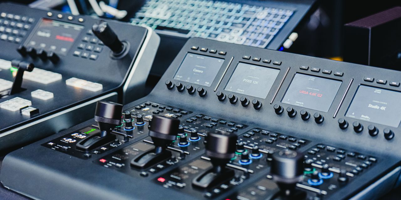 Close-up of a high-tech video editing console with control knobs and screens.