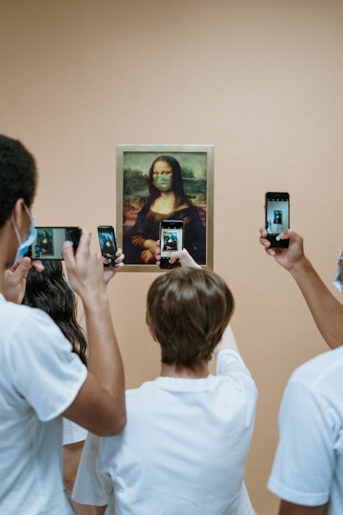 Free People Taking Picture Of Mona LIsa Painting With Face Mask Stock Photo