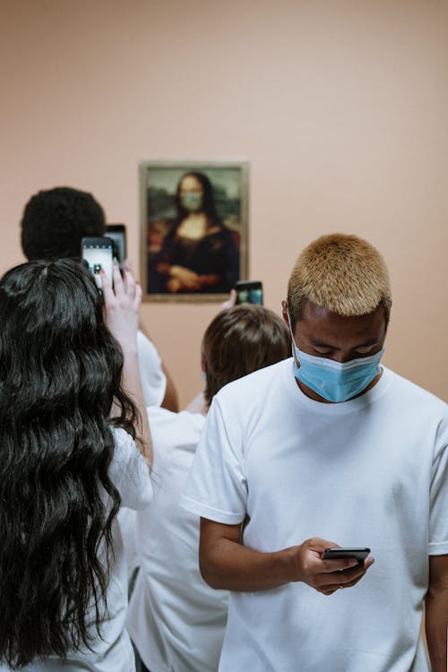 Free Group Of People Looking At A Painting Of Mona Lisa With Face Mask Stock Photo