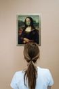 Woman Looking At A Painting Of Mona Lisa Wearing Face Mask