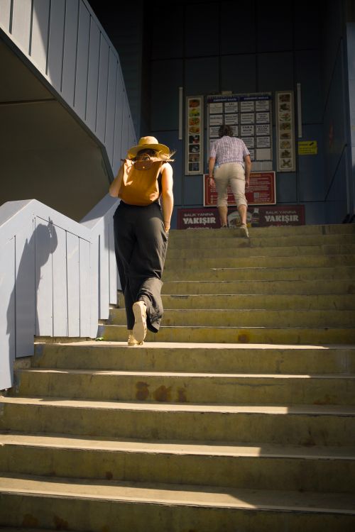 Free Two individuals ascend steps in sunny Istanbul, capturing a moment of urban exploration. Stock Photo