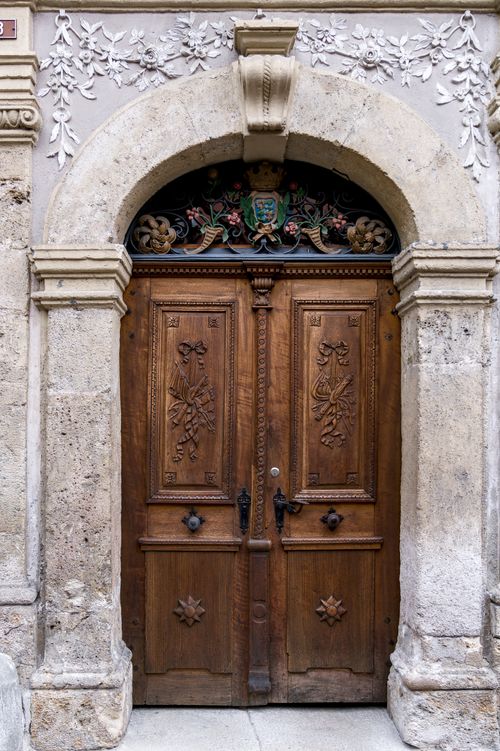 Free Beautifully carved wooden door with intricate stone arch, showcasing Swiss architectural elegance. Stock Photo