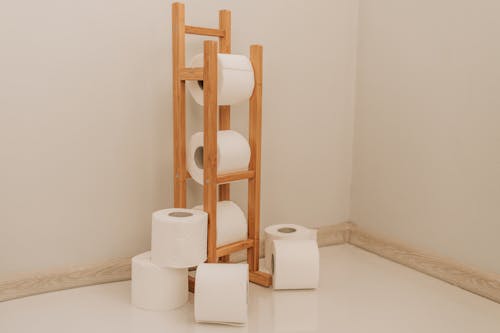 Free White Toilet Paper Rolls on Brown Wooden Rack Stock Photo