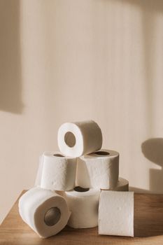 A stack of toilet paper rolls bathed in soft natural lighting, highlighting textures.