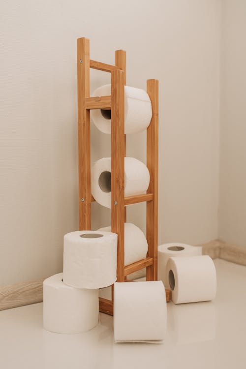 Toilet Paper Rolls on Brown Wooden Rack
