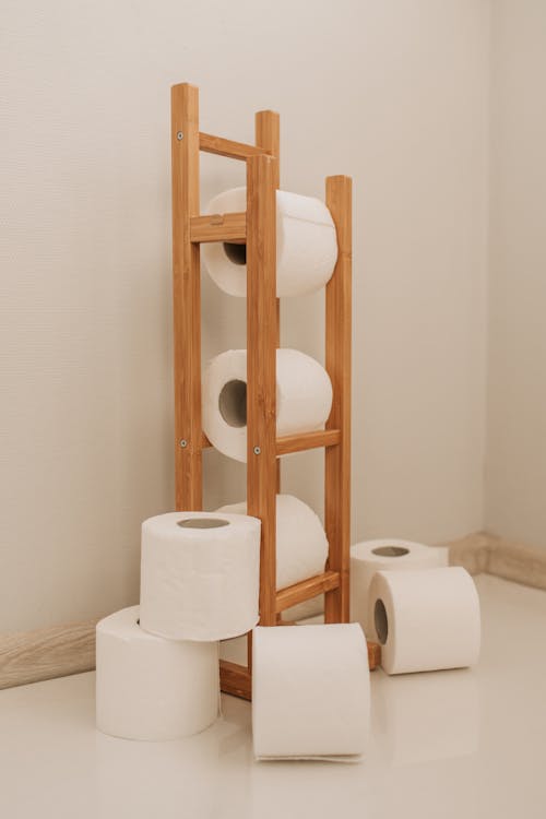 Free Toilet Paper Rolls on Brown Wooden Rack Stock Photo